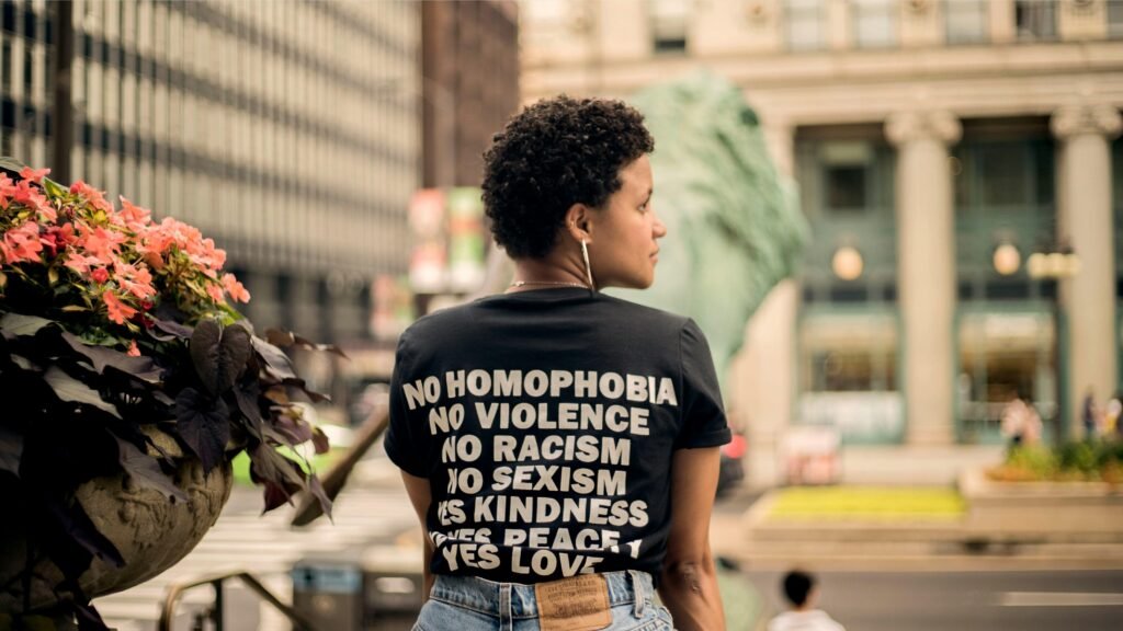 Persona con camiseta que dice: no homophobia, no vilence, no racism, no sexism, yes kidness, yes love, yes peace